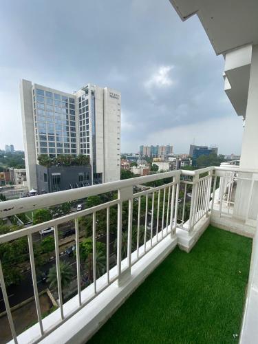 a balcony with green grass and a view of a city at DLF Royal Stay in Lucknow