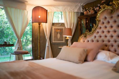a bedroom with a bed and a large window at Glamping Canonici di San Marco in Mirano