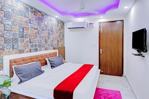 1 dormitorio con 1 cama y TV en la pared en Hotel Green Palace- Near Anand Vihar Railway Station, en Nueva Delhi