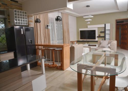 坎帕拉的住宿－Isabirye residence，客厅配有玻璃桌和电视