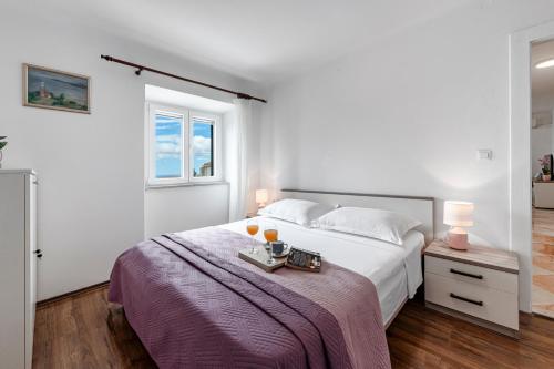 Un dormitorio blanco con una cama con dos bebidas. en Apartment Viki, en Dubrovnik