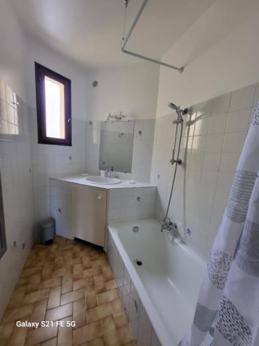 une salle de bain avec une baignoire et un lavabo dans l'établissement T2 bord de mer Agosta, à Albitreccia