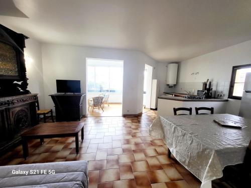 un salon avec une table et une cuisine dans l'établissement T2 bord de mer Agosta, à Albitreccia