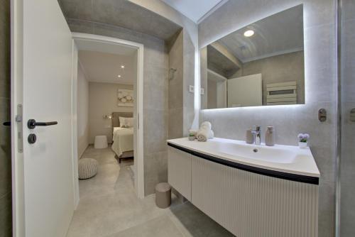 Delux studio apartment Aron with free Parking في بولا: حمام مزود بحوض ومِرآة