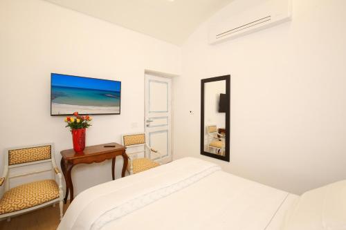 a bedroom with a bed and a desk and a mirror at B&B Domos Mi & Ro in Castelsardo