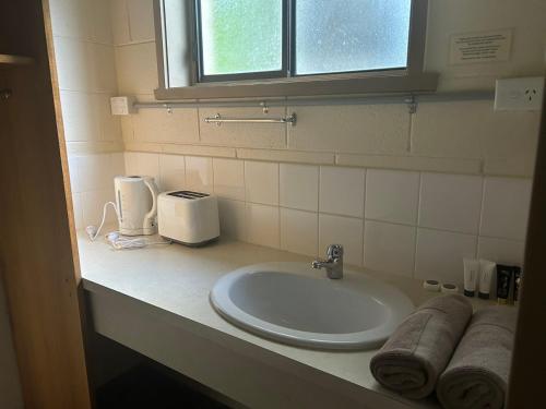 encimera con lavabo y ventana en green gables warburton student camper accomodation en Warburton