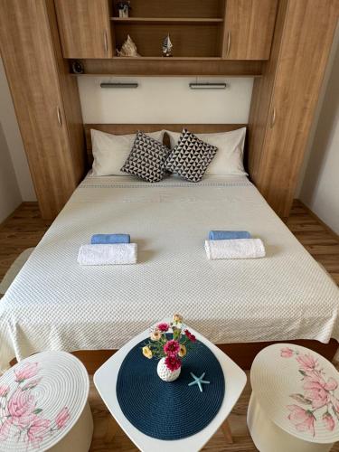 a bed with two plates and a plate with flowers on it at Guesthouse MM in Dubrovnik