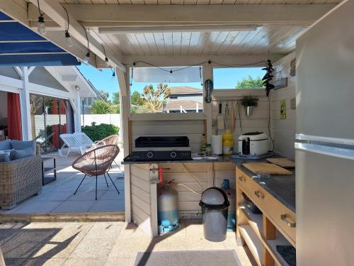 an outdoor kitchen with a stove and a patio at Plaisirs de Lège in Lège-Cap-Ferret