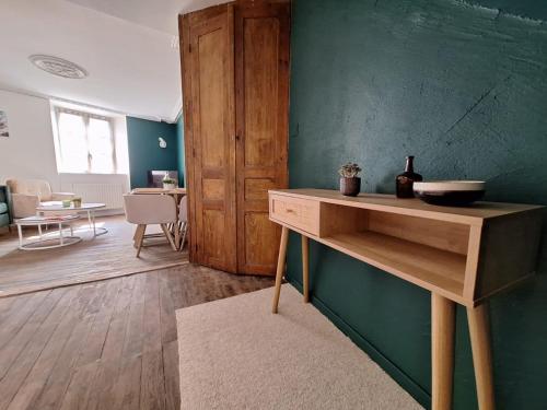 een kamer met een houten tafel en een groene muur bij Superbe maison dans le centre médiéval de Parthenay in Parthenay