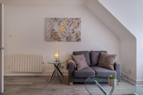 uma sala de estar com um sofá e uma mesa de vidro em Peterhead Stay - SJA Stays - Modern 2 Bed Apartment em Peterhead