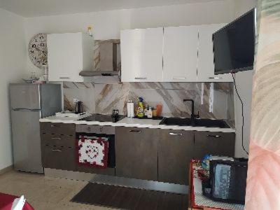 a kitchen with white cabinets and a tv in it at Verona Relax & Stay APARTMENTS in Verona