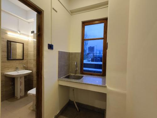 a bathroom with a sink and a window at Zanu Residency in Leh