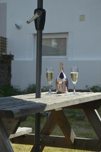 a picnic table with two glasses of wine on it at Ryde Beach Garden Apartment in Ryde