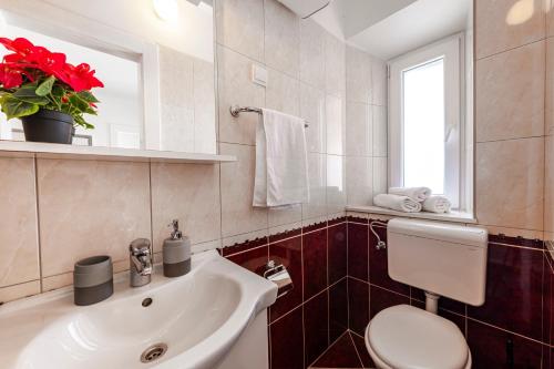 baño con lavabo y aseo y ventana en Apartment Viki, en Dubrovnik