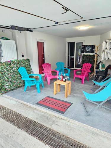 - un ensemble de chaises et de tables colorées sur une terrasse dans l'établissement Les Fées Mer : appart 150 m² hypercentre calme 10p, à Chamonix-Mont-Blanc