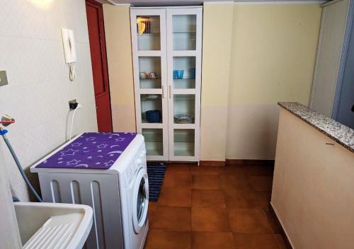 a laundry room with a washing machine and a sink at Casetta indipendente MottaSant'anastasia in Motta SantʼAnastasia