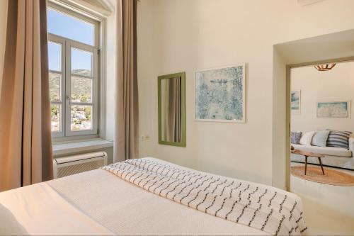 um quarto branco com uma cama e uma janela em Hydra Hotel em Hidra