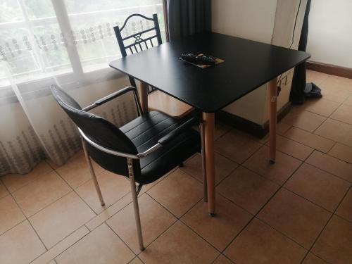 a black table and chair in front of a window at Joy suites emeli in Nairobi