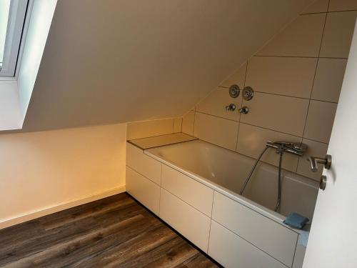 un bagno con vasca in mansarda di Ferienwohnung im Resi Gesundheitszentrum a Freudenberg