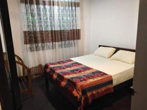a small bedroom with a bed and a window at Villa Freedom in Ahangama
