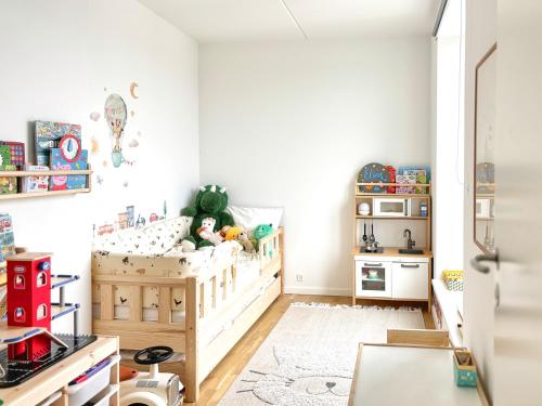 a small childs bedroom with a crib and a table at Modern Apartment with Amazing Views in Copenhagen