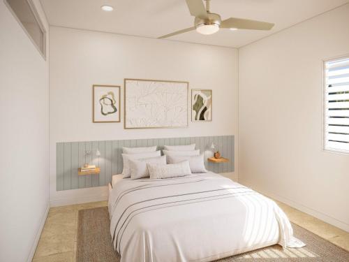 a white bedroom with a large bed with white sheets at The Health Lodge in Byron Bay