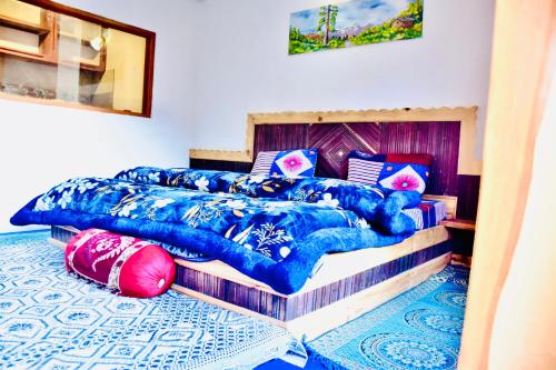 a bedroom with two beds with blue comforter at Manali Mist in Jagatsukh