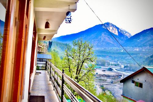 a balcony of a building with a view of mountains at Manali Mist in Jagatsukh