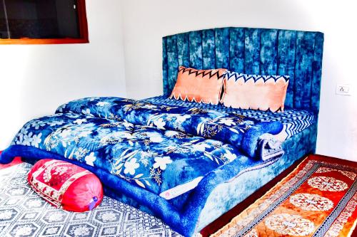 a bed with a blue patterned sheets and pillows at Manali Mist in Jagatsukh