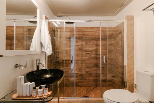 a bathroom with a sink and a shower at Hydra Hotel in Hydra