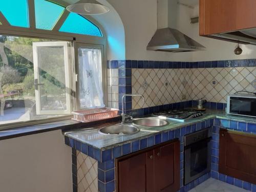 a kitchen with two sinks and a window at La terrazza di Valeria in Scario