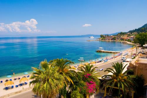 a view of a beach with palm trees and the ocean at Potamaki Beach Hotel in Benitses