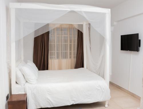 a white bed with a canopy in a bedroom at Sunnyside Inn in Blantyre