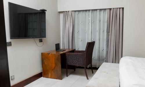 a room with a desk and a television and a bed at Sunnyside Inn in Blantyre