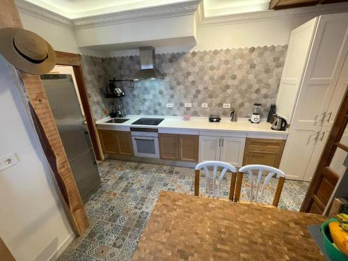 a kitchen with a refrigerator and a table and chairs at Las Caletillas vacations, 20 meters from the beach in Santa Cruz de Tenerife
