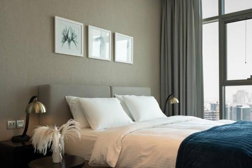 Business Bay centrally located Cozy Studio في دبي: غرفة نوم بسرير وملاءات بيضاء ونافذة
