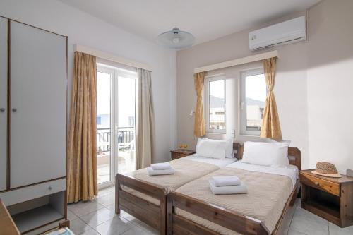 a bedroom with a bed with two towels on it at Litsa Mare Apartments in Agia Pelagia