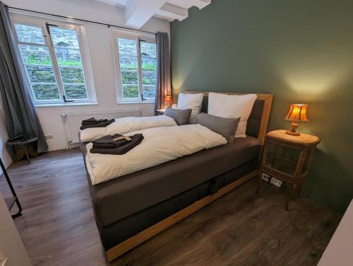 een slaapkamer met een bed en een lamp op een tafel bij Residenz Vier Jahreszeiten Monschau in Monschau
