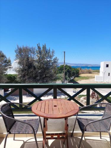 a table and chairs on a balcony with the beach at Magic Land in Plaka
