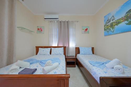 2 Betten in einem Schlafzimmer mit Handtüchern darauf in der Unterkunft Vila Kristian in Ksamil