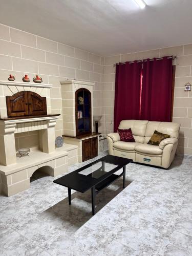 a living room with a couch and a table at Marsaskala Sea Side Retreat in Marsaskala