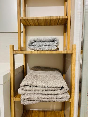 - 2 serviettes sur une étagère en bois dans la salle de bains dans l'établissement T1 Bis tres proche centre et canal, à Narbonne