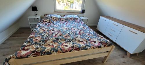 a bedroom with a bed with a bedspread with animals on it at Apartamenty Drewniaki in Rydzewo