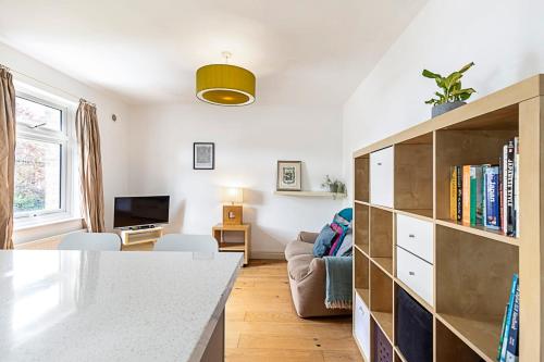 - un salon avec une étagère et un canapé dans l'établissement A Tranquil One-Bedroom Flat near Brockwell Park, à Londres
