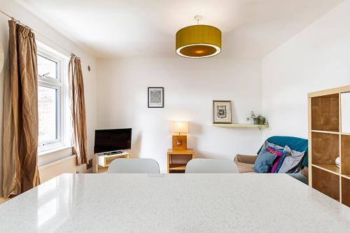 a kitchen and living room with a table and chairs at A Tranquil One-Bedroom Flat near Brockwell Park in London