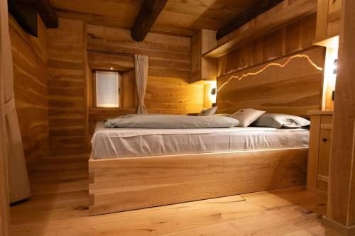 a bedroom with a bed in a wooden room at Ad Maiora Baita Walser with SPA in Alagna Valsesia
