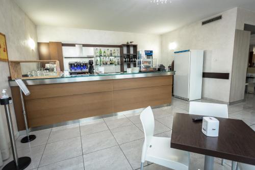 a restaurant with a bar with a table and a refrigerator at HOTEL DON CAMILLO in Brescello