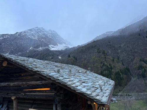 a roof of a log cabin with mountains in the background at Ad Maiora Baita Walser with SPA in Alagna Valsesia