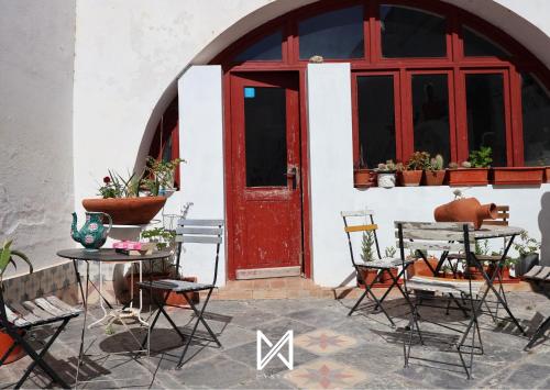 a red door on a white building with a table and chairs at MyStay - A Casa do Visconde in Mértola