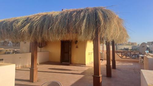 a hut with a straw roof on top of a building at Luxury Chalet in Mountain View 2 , El-Sokhna with Sea View , Pool View "Heated Pool" and Garden View Families Only in Ain Sokhna